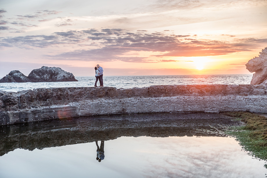 stunning sunset reflection engagement photo of the happy couple at Sutro Baths, San Francisco