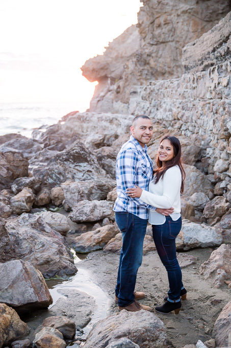 sweet couple standing next to the ocean