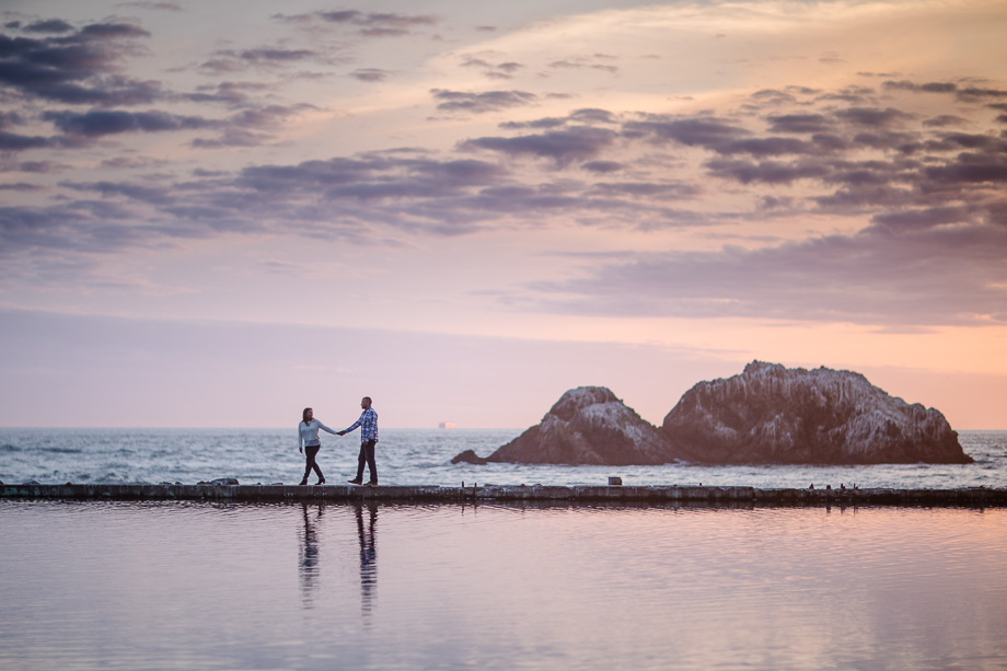 gorgeous photo of the couple walking on the Sutro Baths ruins along the water