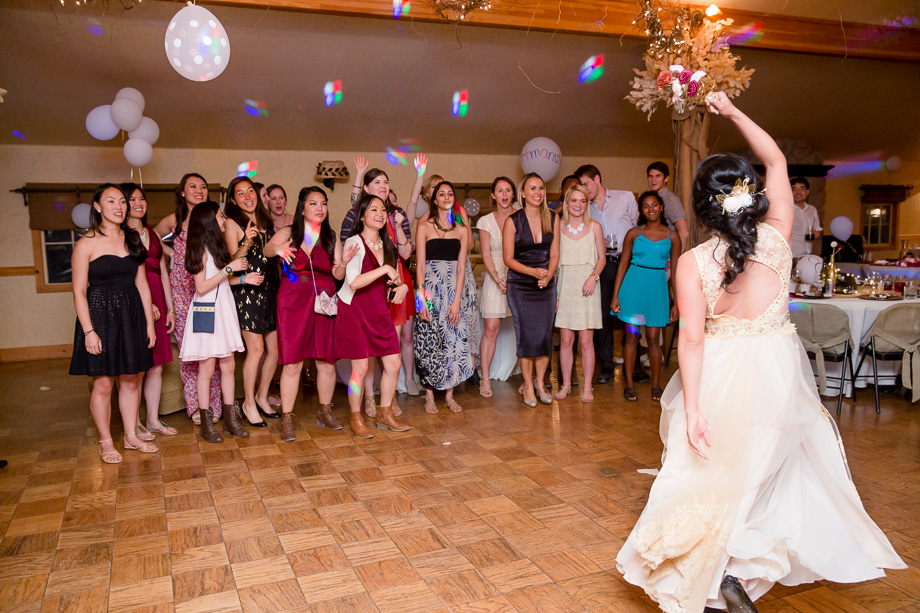 bride teasing single girls with the bouquet toss