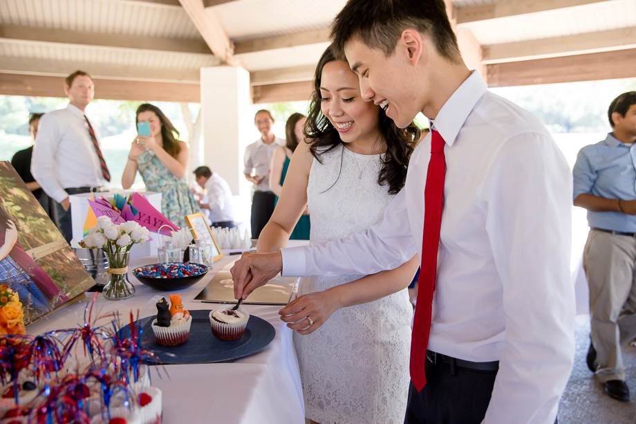 newlyweds cutting their wedding cupcake