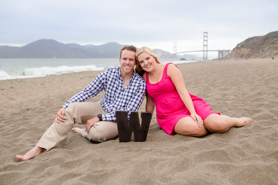 clean and bright engagement photo at Baker Beach, San Francisco with a custom monogram sign