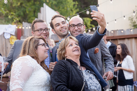 wedding guests taking a selfie with the bride and groom