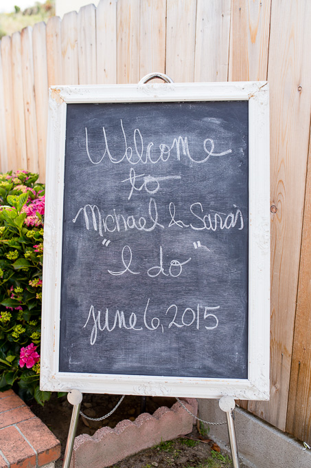 Handwritten chalkboard welcome sign for an intimate backyard wedding