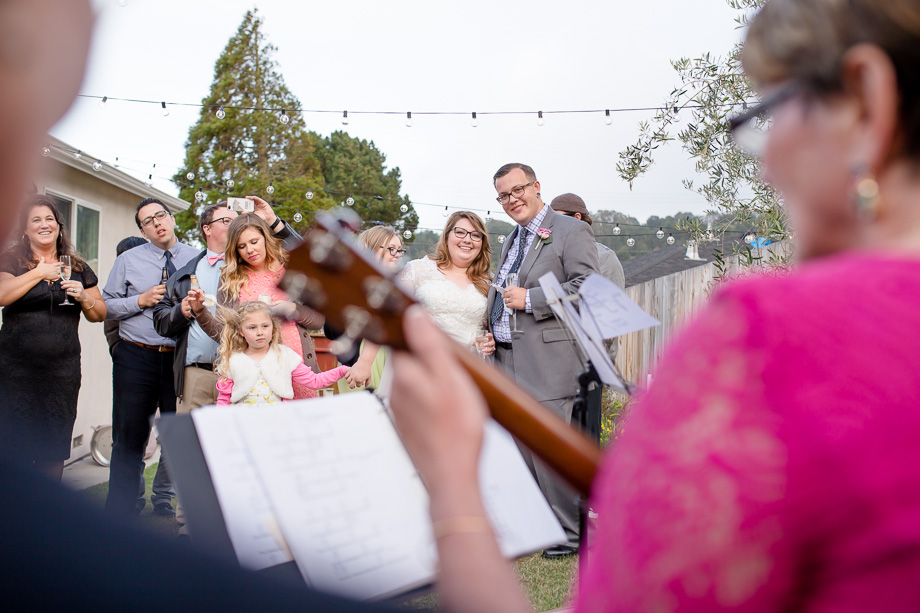bride and groom enjoying familys surprise music performance