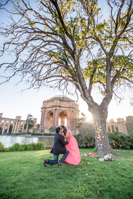 newly engaged couple kissing in front of Palace of Fine Arts after their proposal