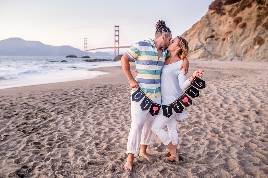 beautiful beach engagement photo during sunset in front of Golden Gate Bridge