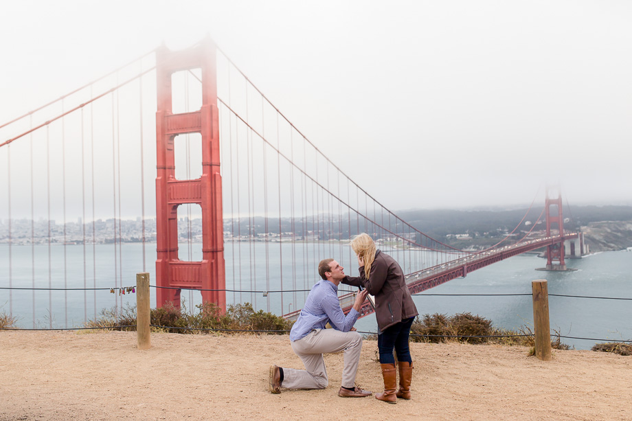 romantic surprise proposal photo at Battery Spencer in front of the Golden Gate Bridge covered in a little fog
