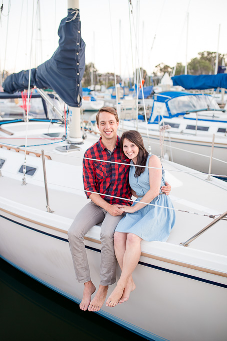 couple sitting on their own sailboat for their engagement pictures