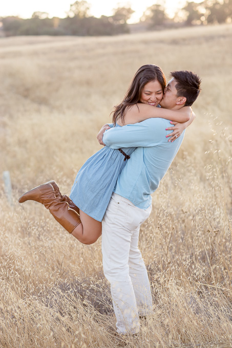happily engaged couple in a rolling grassy field
