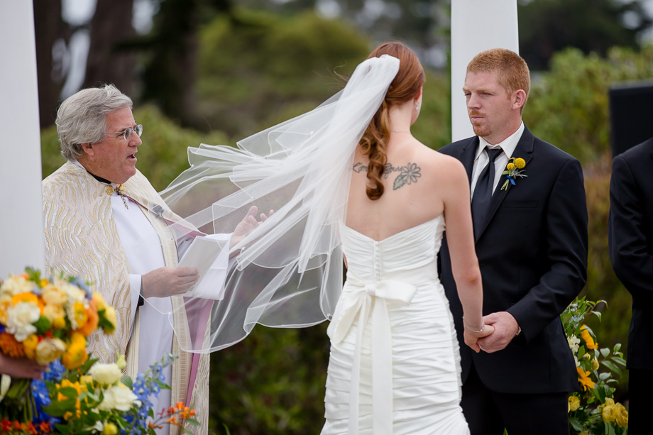 pretty bridal veil flies with the wind during outdoor wedding ceremony