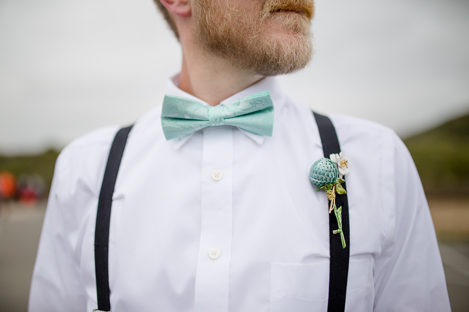 a close up of grooms blue bowtie and blue boutonniere - half moon bay real wedding