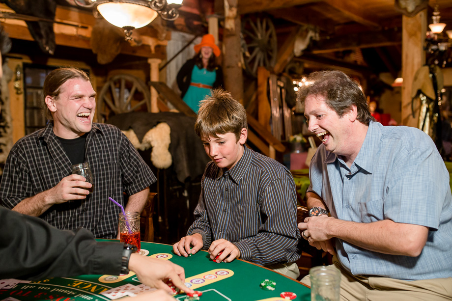 wedding guests having fun at the poker table inside the farm house at long branch saloon, half moon bay