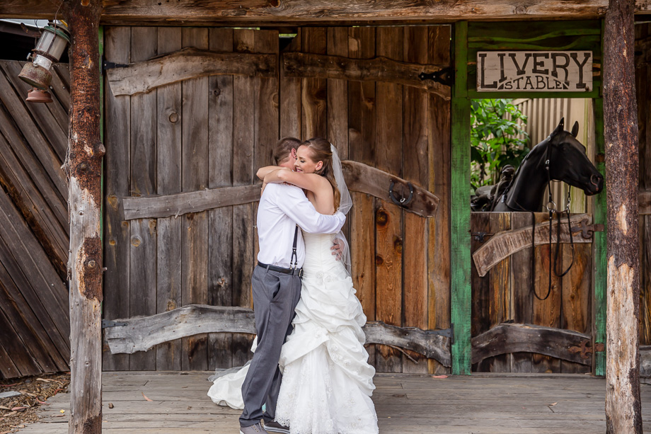 a romantic first look in front of a rustic farm house