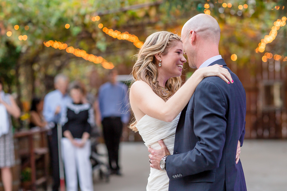 newlyweds first dance in garden with background string lighting