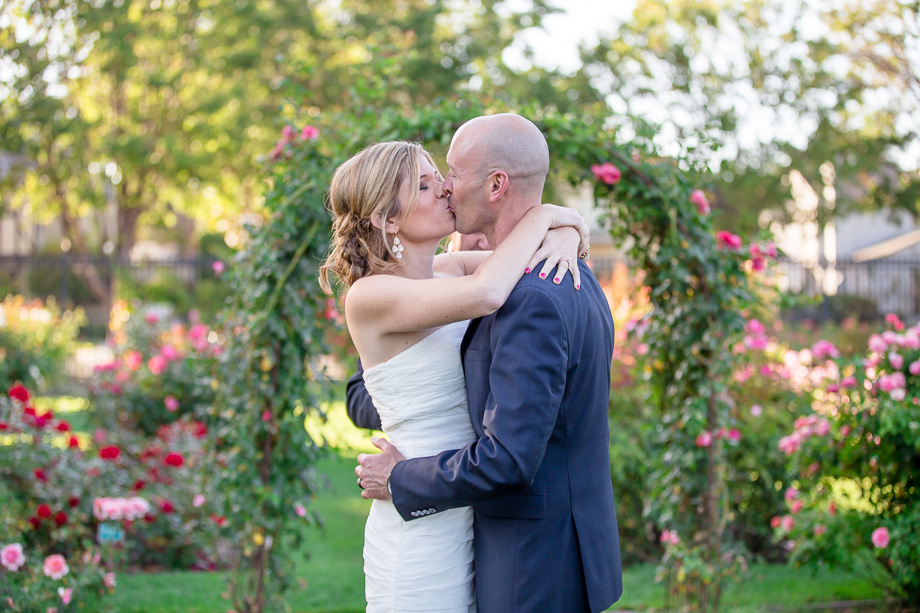 bride and groom kissing after outdoor intimate wedding ceremony at rose garden