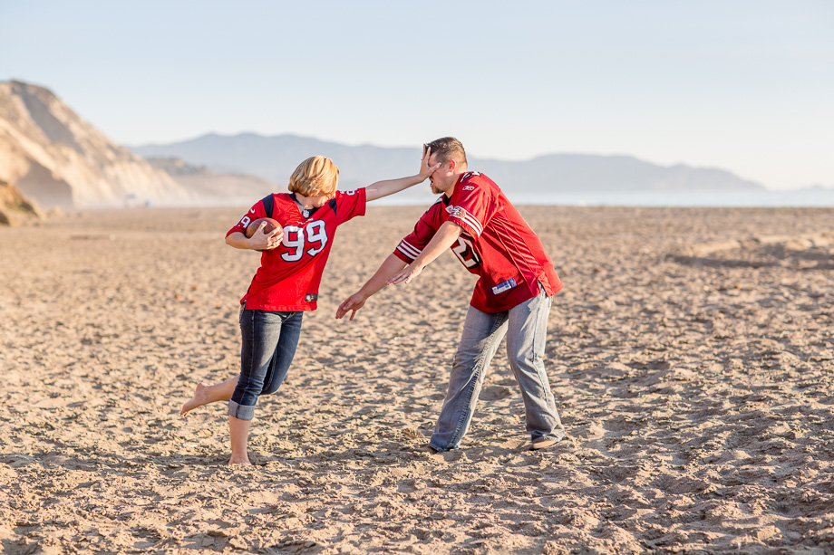 fun and creative football engagement photo on a beach - northern california lifestyle engagement photographer