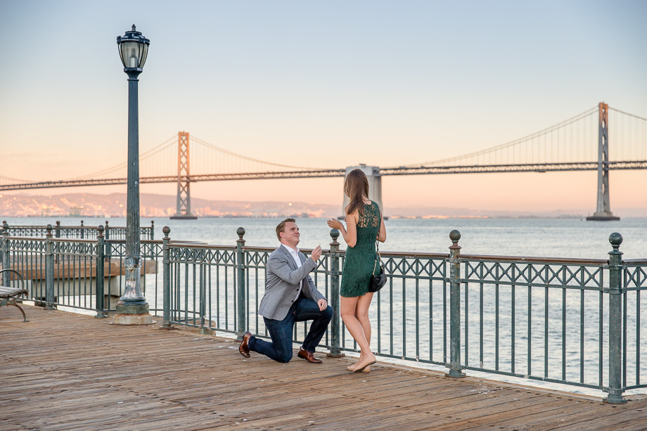 a romantic sunset surprise proposal in San Francisco in front of the Bay Bridge