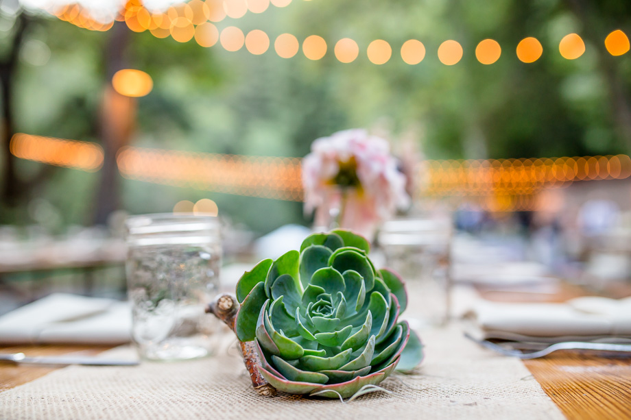 simple and beautiful succulent and mason jar centerpiece on burlap table runner