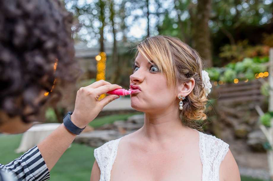 bride making funny face and touching up lipstick