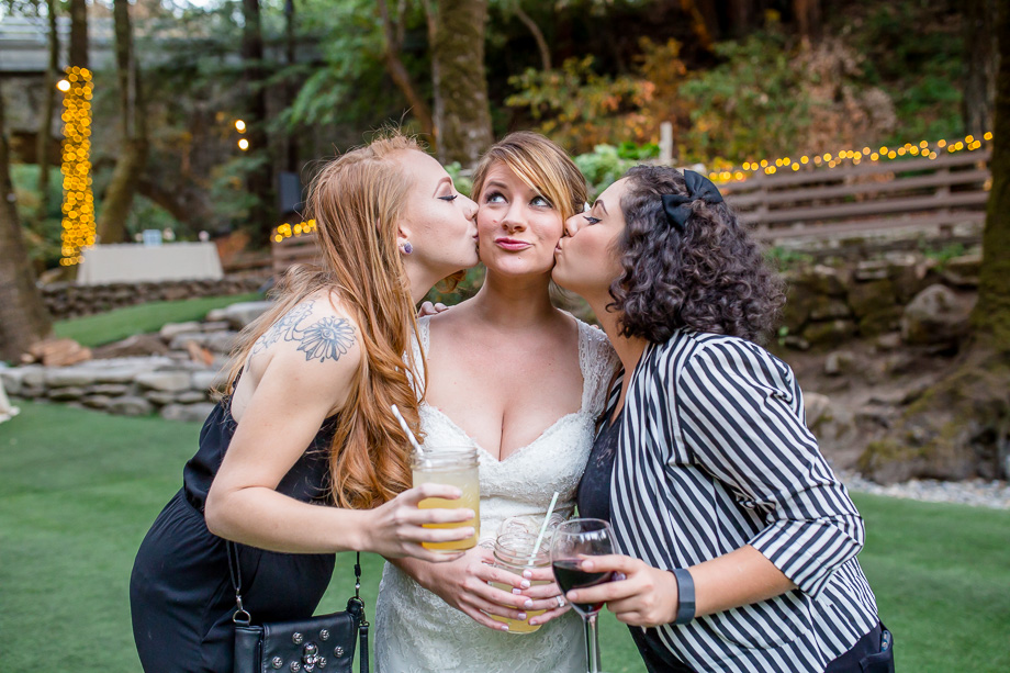 friends giving bride a kiss