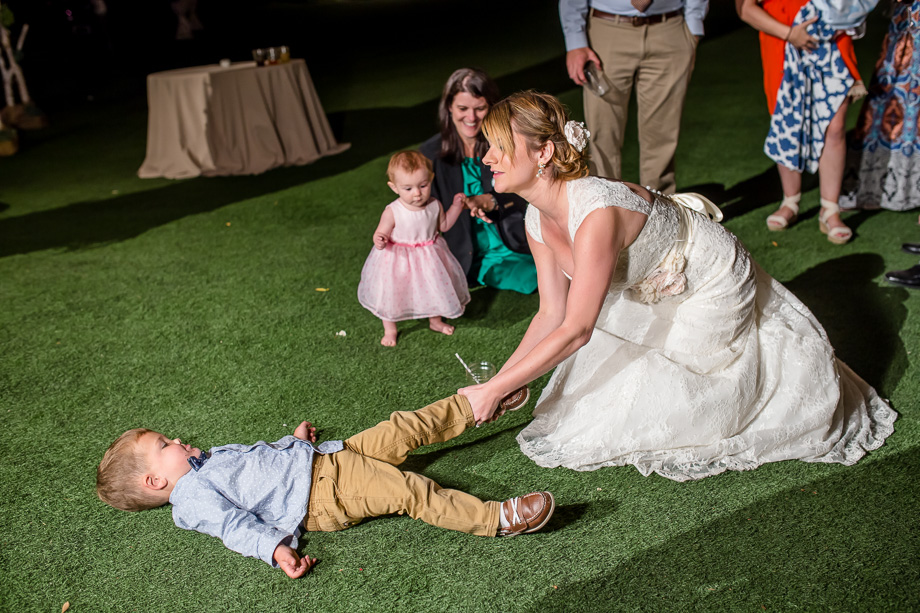bride playing with a toddler during the reception