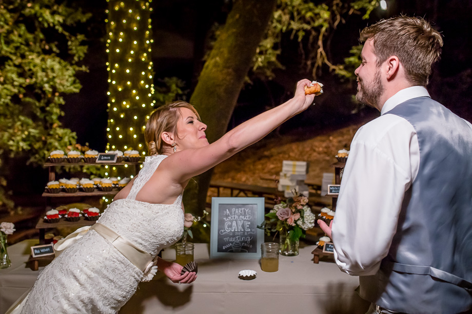 bride trying to smash cupcake into groom's face