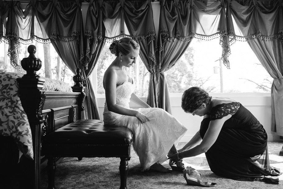 bride's mother helping her put on shoes
