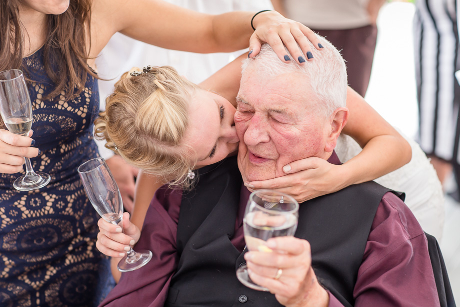 bride giving grandpa a kiss on the cheek - emotional wedding photo
