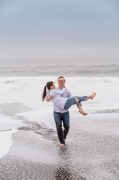 boyfriend carrying girlfriend on the beach in the waves