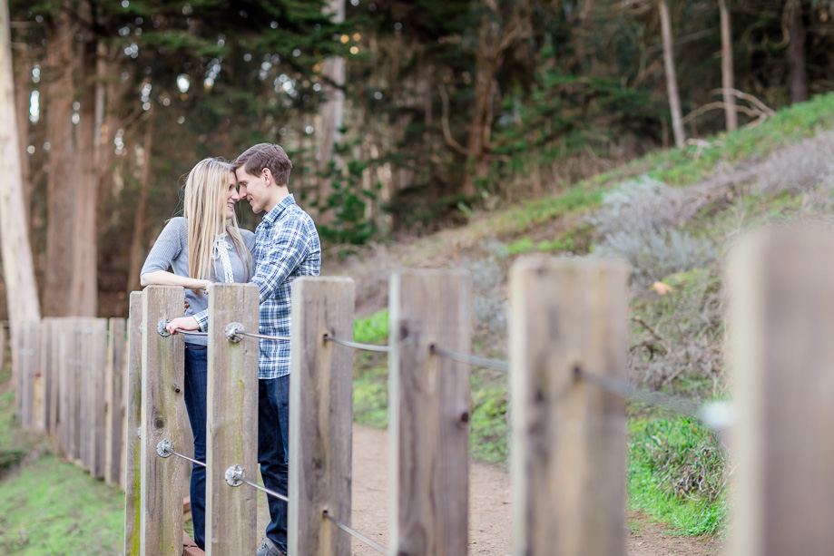 engagement photo at Presidio along wooden fence