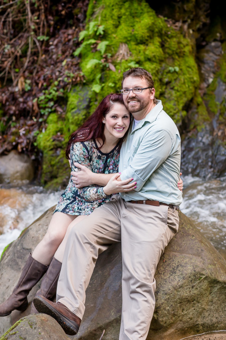 engagement photo sitting on a rock in a river