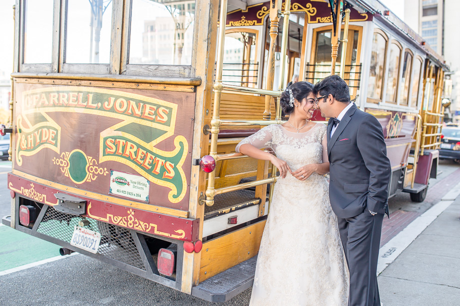 newlyweds with a cable car parked right outside of San Francisco City Hall