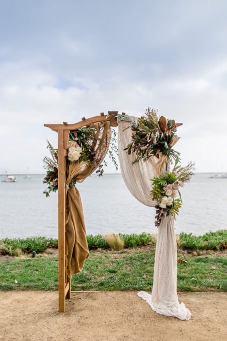 arch floral arrangement for a romantic seaside wedding ceremony