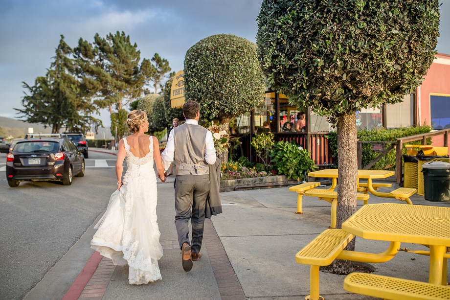 candid photo of bride and groom walking to the jetty from the reception venue