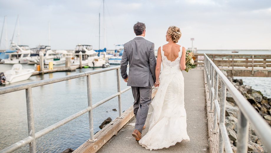 candid photo of bride and groom walking on the jetty - Mavericks Event Center wedding