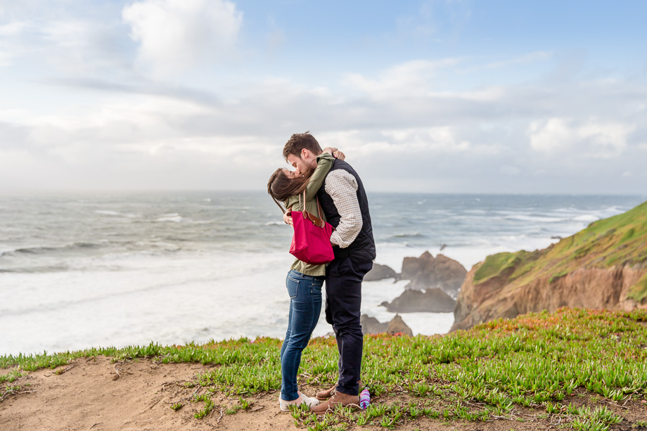 kissing after proposal overlooking Pacific shore coastline cliffs