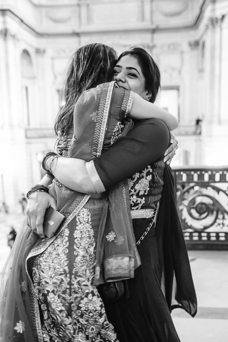 bride and sister hugging after wedding