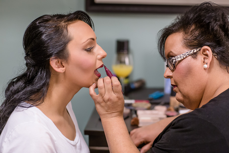 mother putting on lipstick for daughter