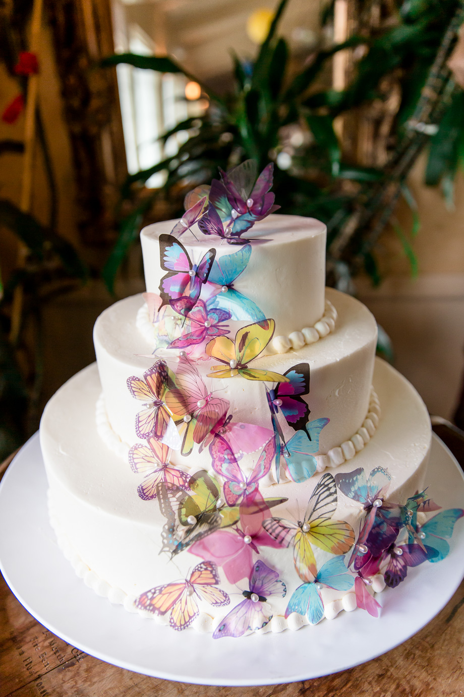 whimsical wedding cake with layers of butterflies
