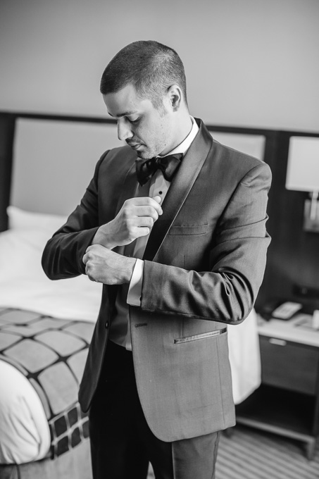 groom getting ready putting on suit