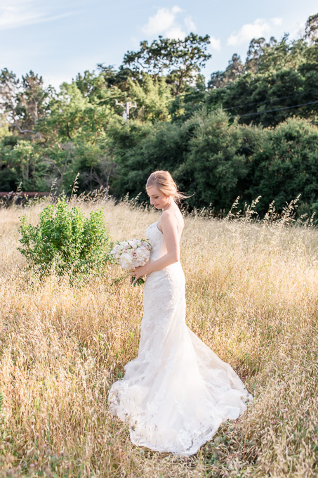 beautiful bride standing in a windy field