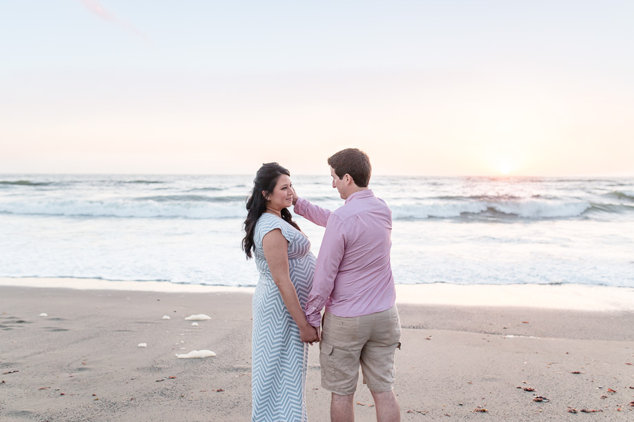 sweet candid moment perfectly captured by the photographer during a beach maternity photo session