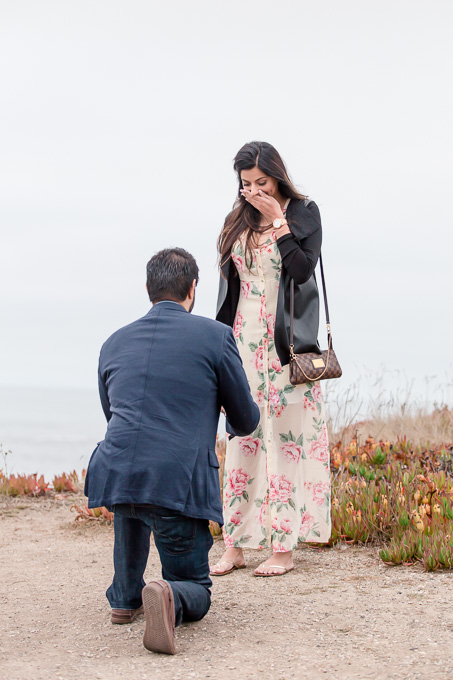 precious facial expression during a surprise proposal at half moon bay shoreline