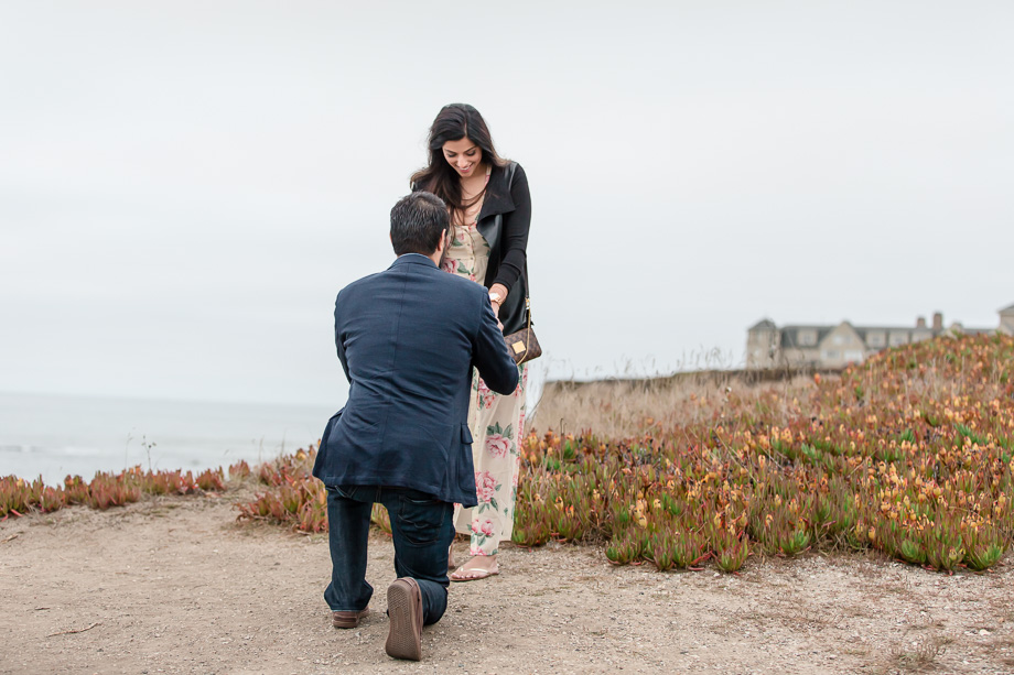 a surprise marriage proposal on a overcast day by the Paciifc ocean