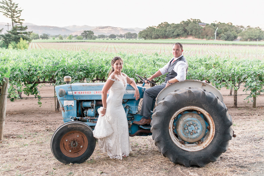 bride and groom with the blue tractor in the vineyards