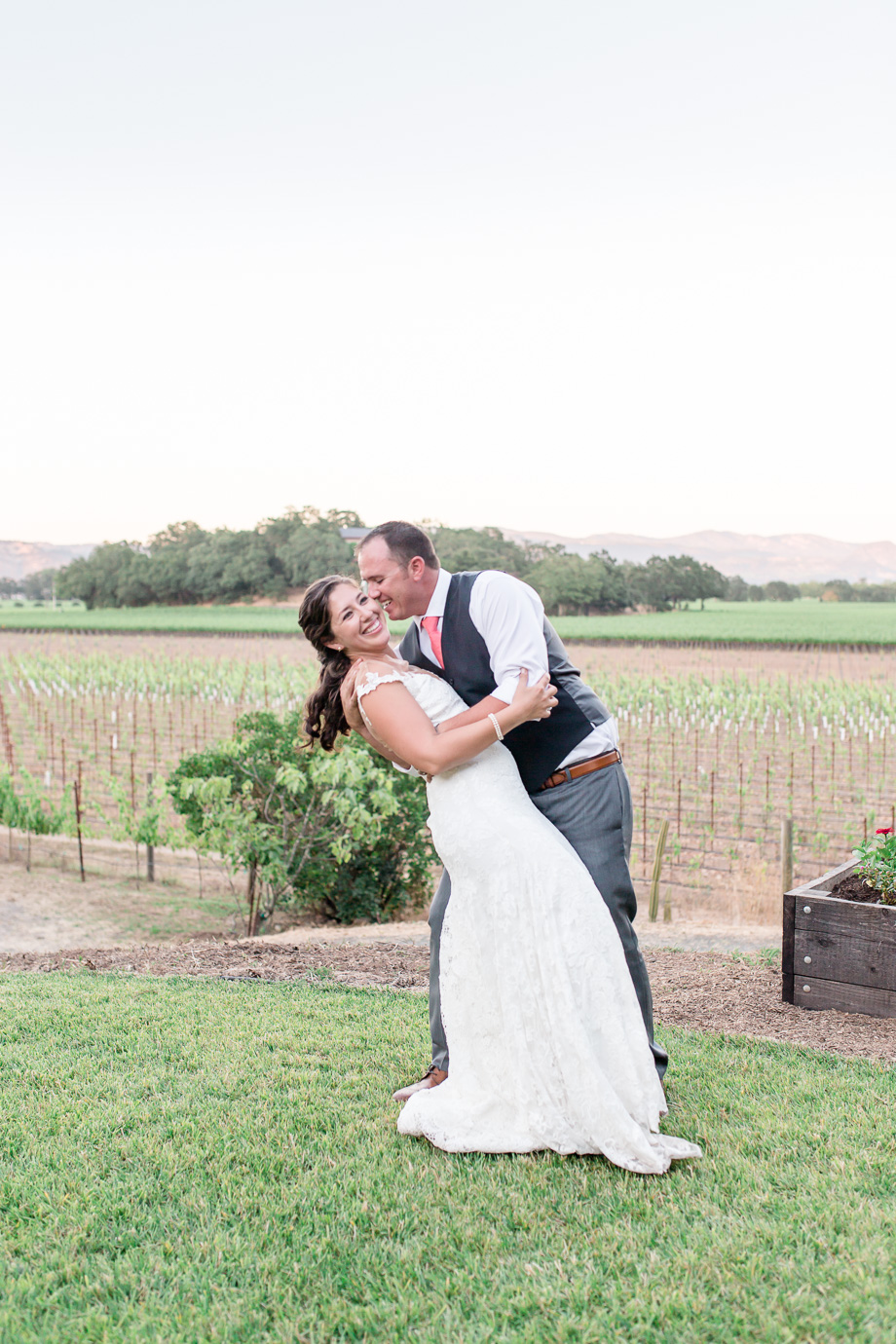 bride and groom with the vineyards that they care for everyday