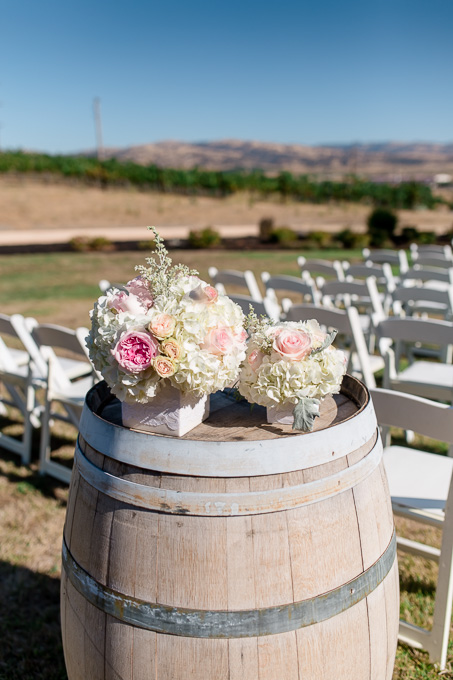 winery wedding decor idea - fresh flowers on wine barrels