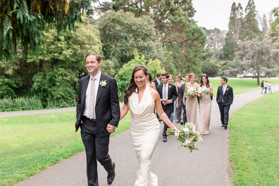 bride and groom walking with wedding party in golden gate park