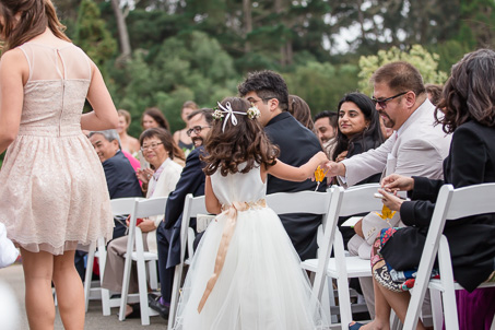 flower girl handing out golden origami cranes to the wedding guests